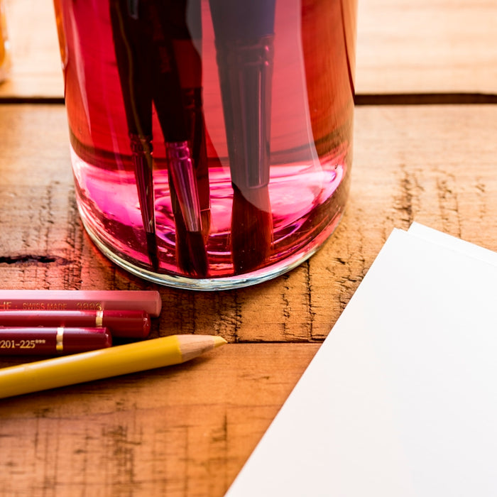 colored pen beside white printer paper on wooden surface