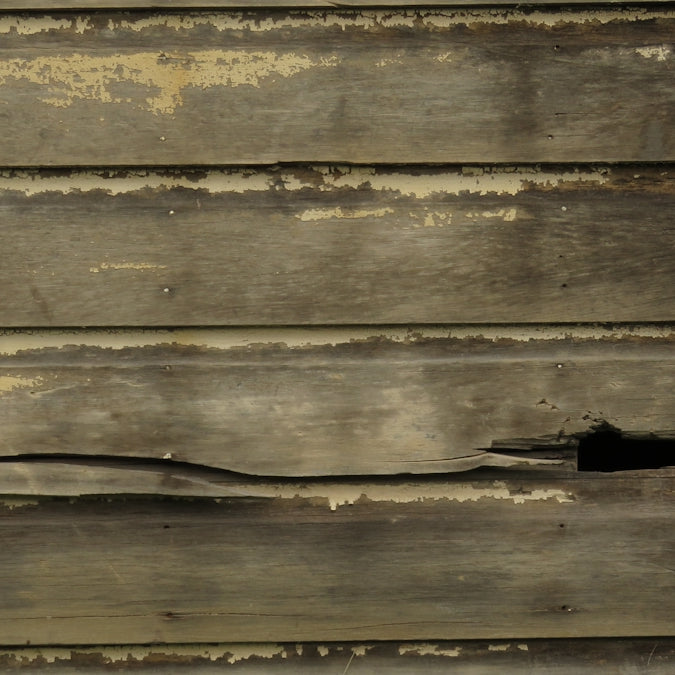 a close up of a wooden wall with peeling paint