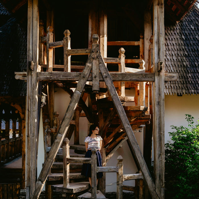 woman standing on wooden spiral stairs