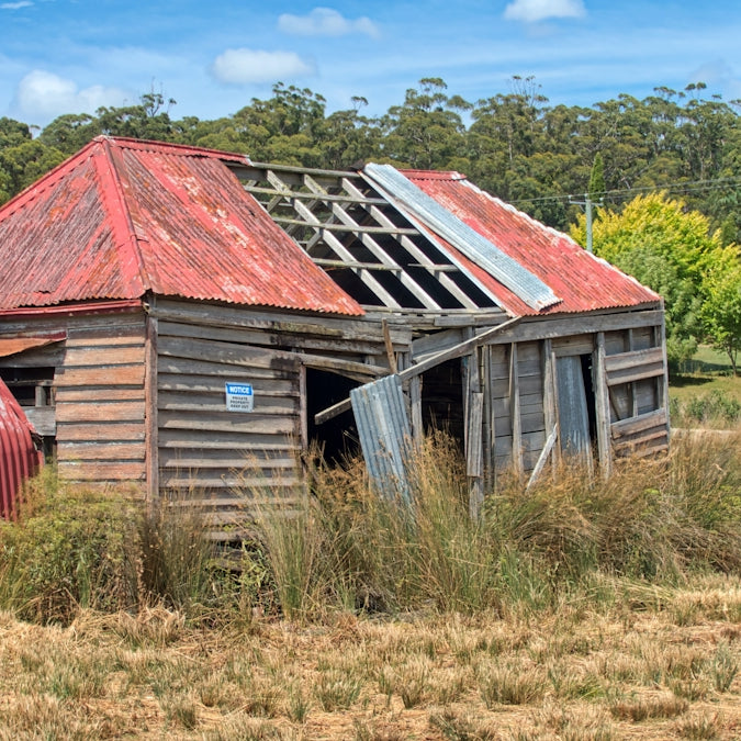 brown wooden house on green grass field during daytime