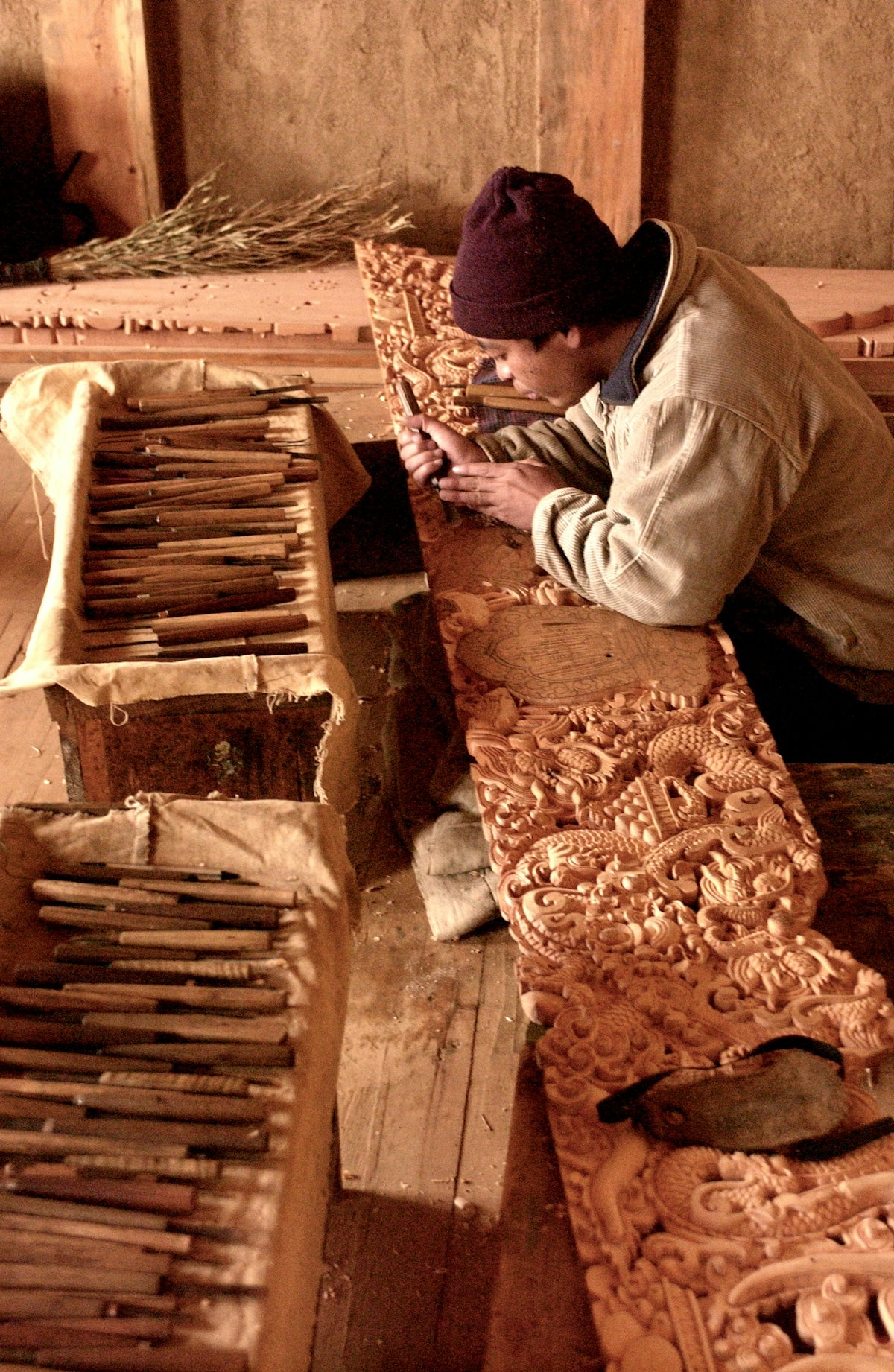 man in white dress shirt and black knit cap sitting on brown wooden stairs