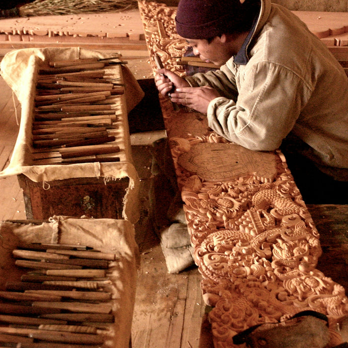 man in white dress shirt and black knit cap sitting on brown wooden stairs