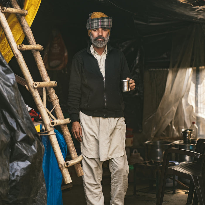 a man standing in a tent holding a cup