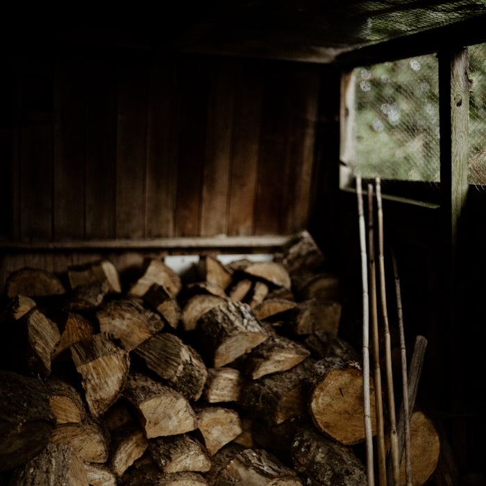 a pile of wood sitting inside of a wooden shed