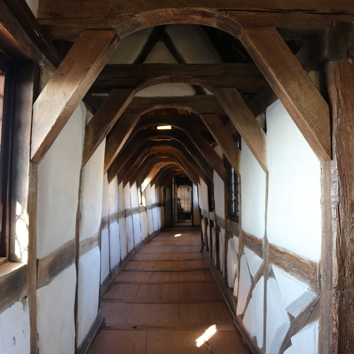 a long hallway with wooden beams and windows