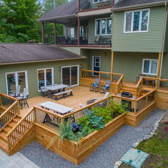 a deck with chairs and tables on it and a deck with plants