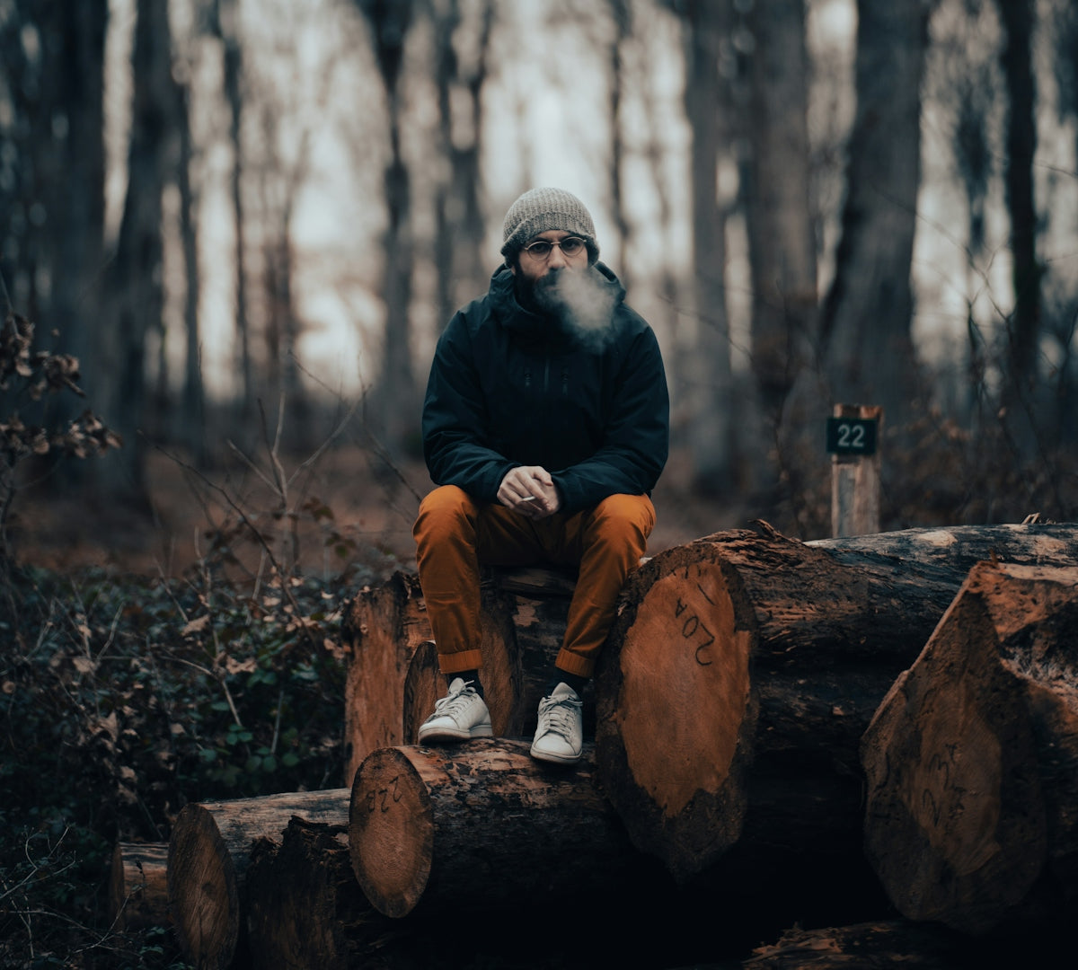 a man sitting on a log in the woods