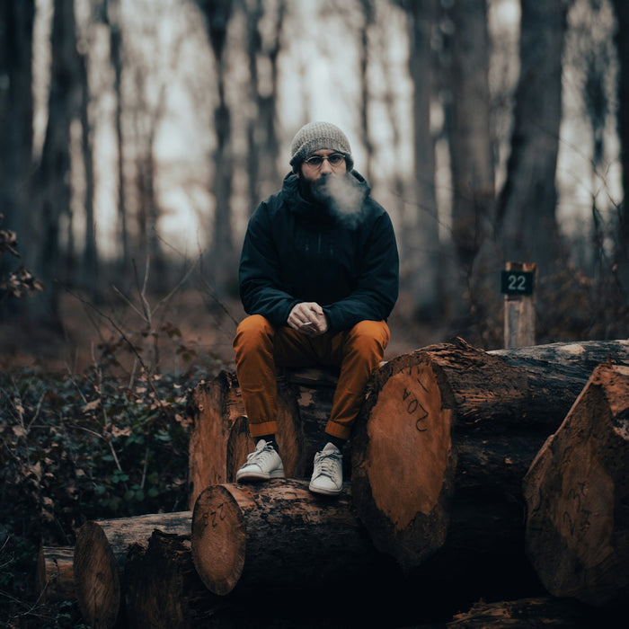 a man sitting on a log in the woods
