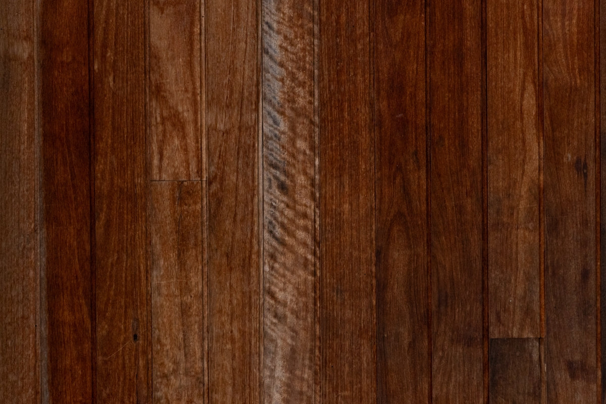 A close up of a wooden floor with a brown stain