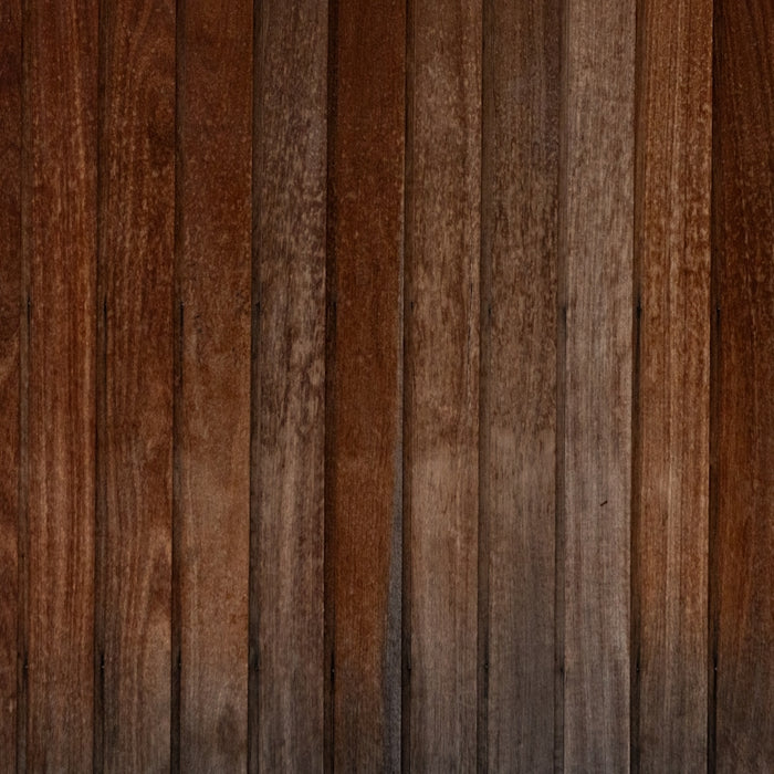A wooden wall with a black and white cat sitting on top of it
