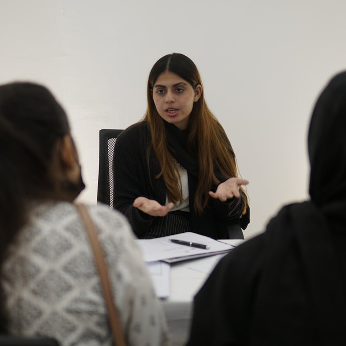 Woman gesturing while talking to two people